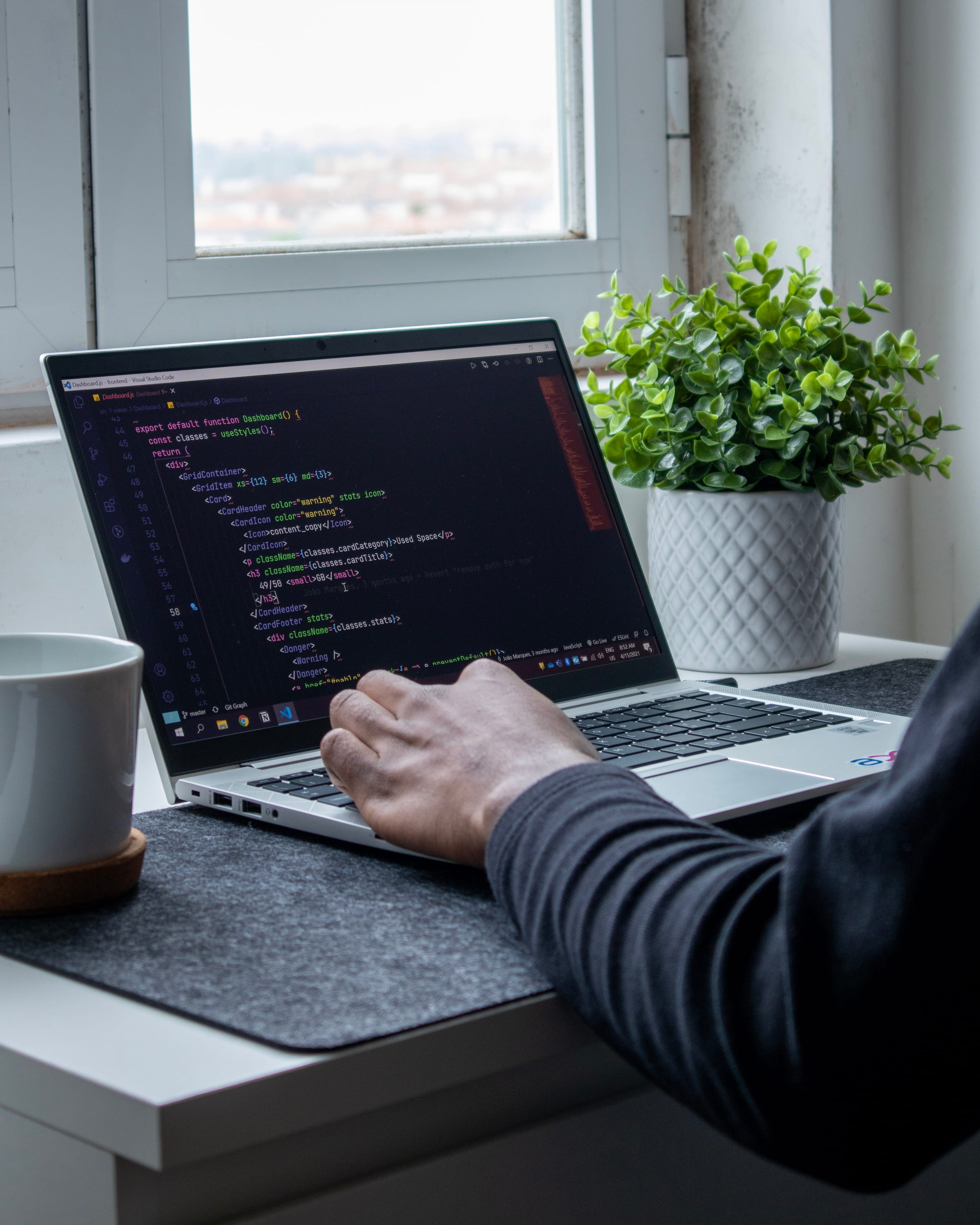 Developer working on laptop with code and software development in focused sprint environment